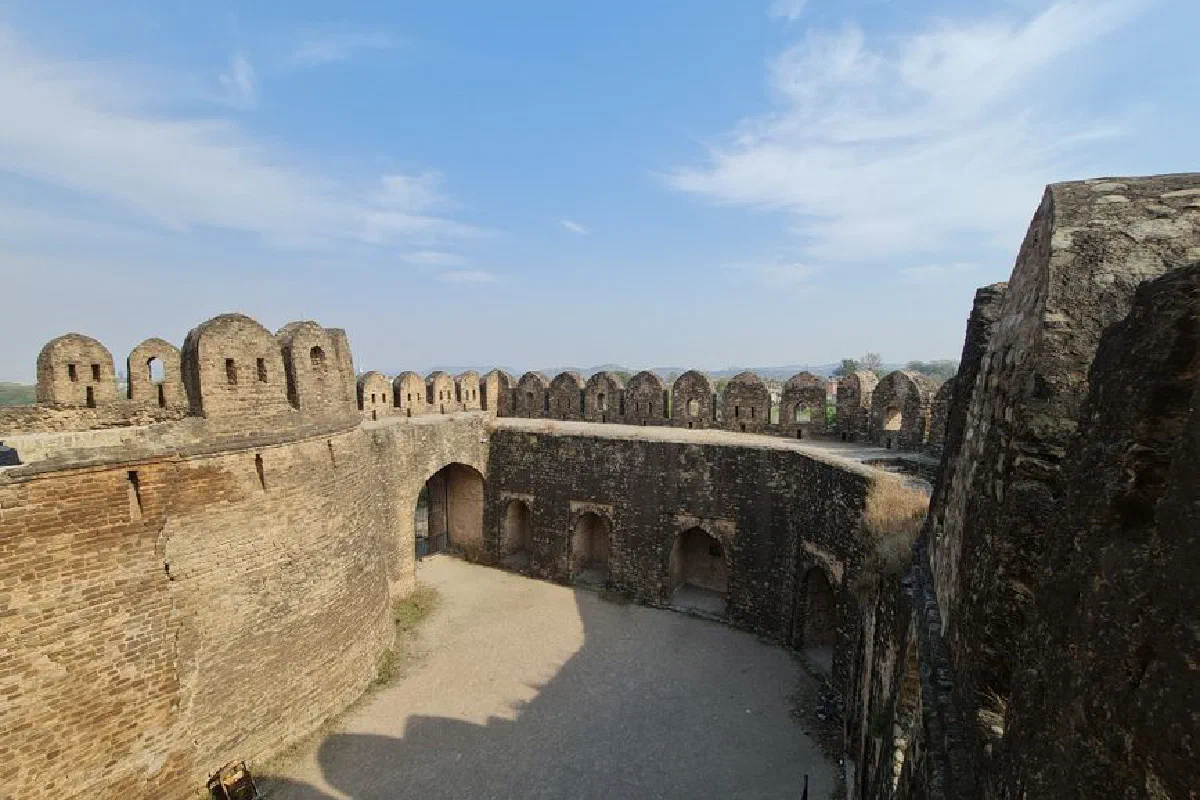 Historic stone fortress with arched towers under a clear blue sky.