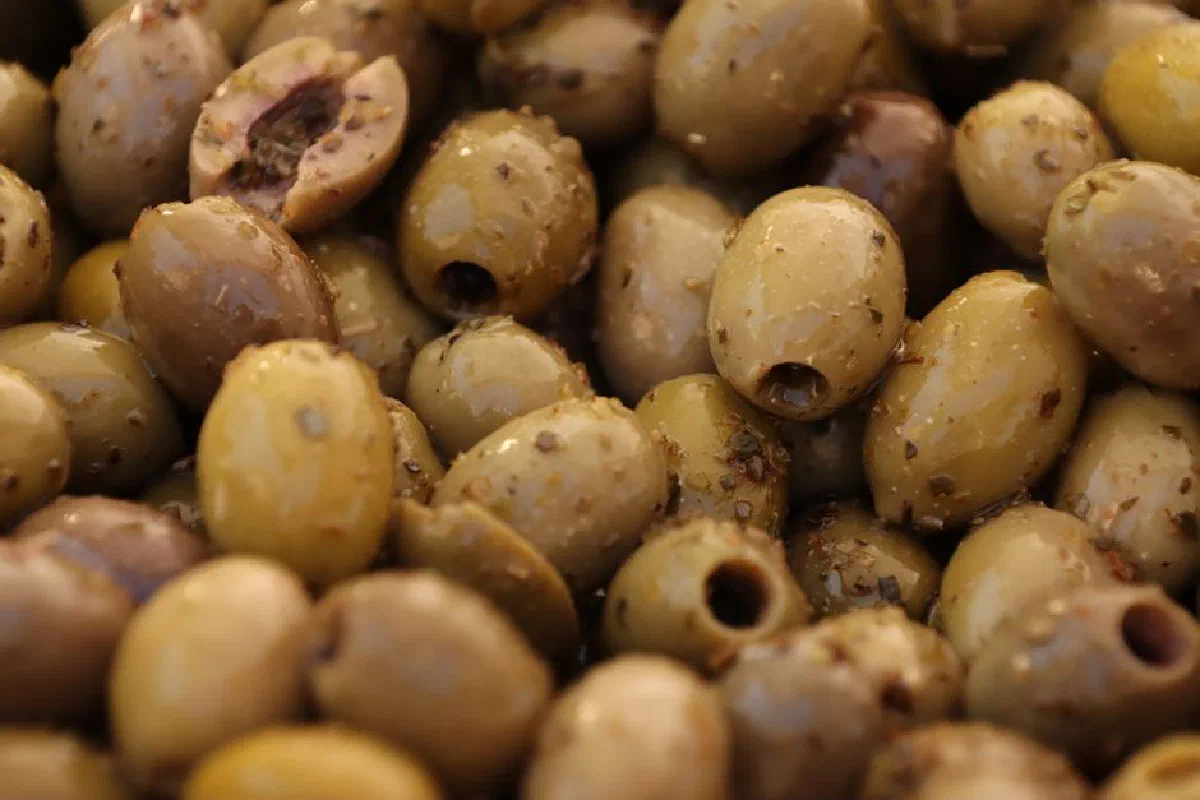 A detailed close-up shot showcasing seasoned green olives, perfect for food photography.