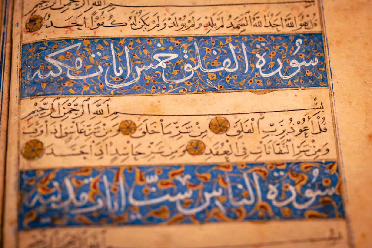 Close-up of an illustrated Arabic manuscript page with intricate calligraphy and floral patterns.