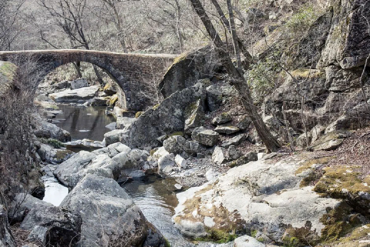 Explore the serene landscape of Suncheon with a historic stone bridge over a tranquil river.