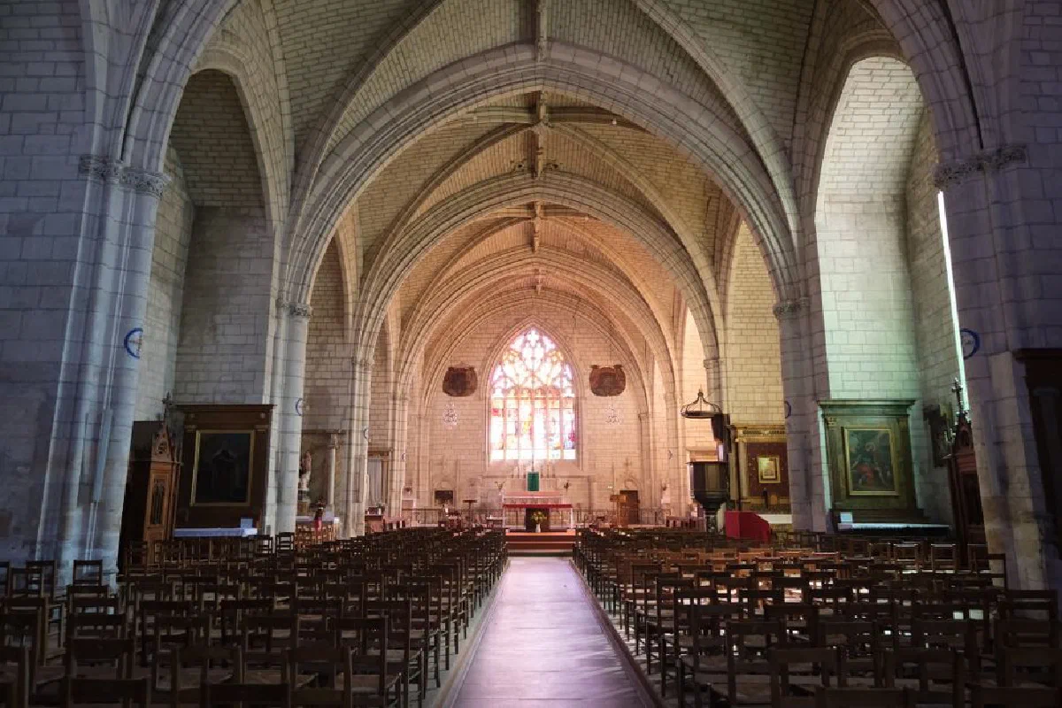 Explore the serene and majestic architecture of this historic church interior with rows of empty pews and stunning stained glass windows.