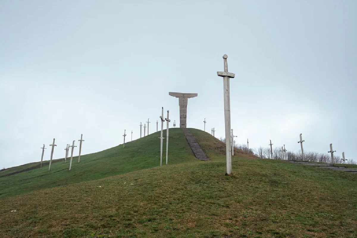 A serene landscape of wooden crosses on a green hillside in Mtskheta-Mtianeti, Georgia.