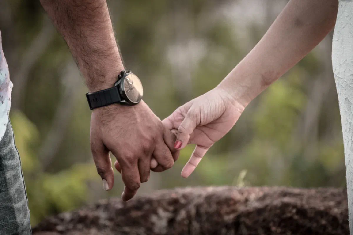 Heartfelt close-up of a couple holding hands, symbolizing love and connection.