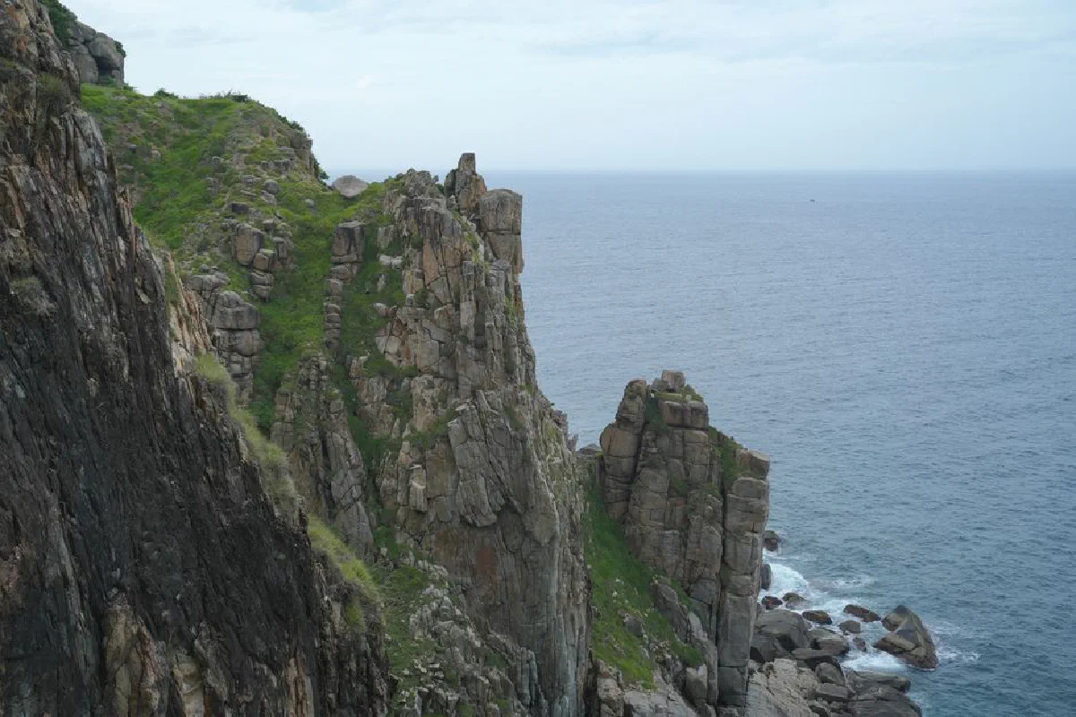 Majestic rocky cliff overlooking the ocean, showcasing natural beauty and geological formations.