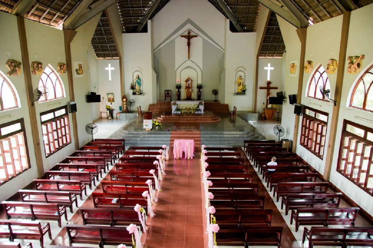 A serene church interior showing wooden benches and a central altar under soft lighting, perfect for worship.