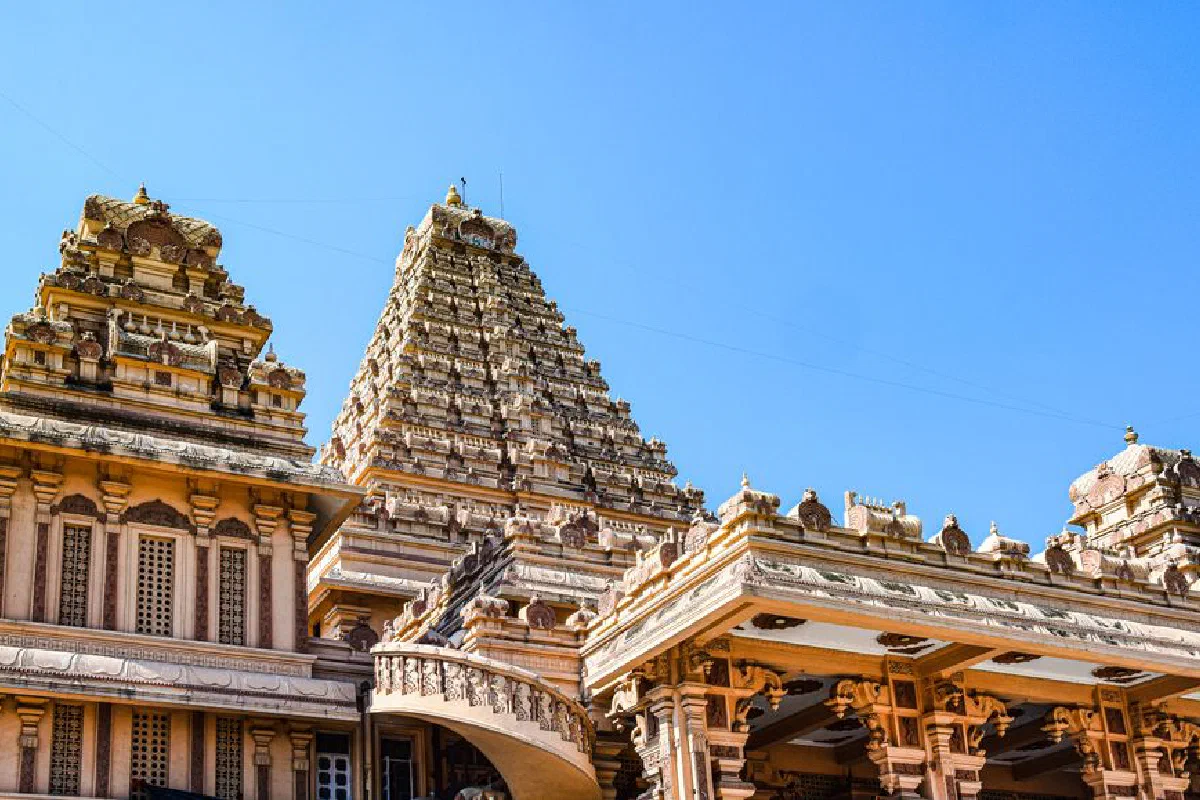 Intricate architecture of a Hindu temple under a clear blue sky enhances cultural exploration.