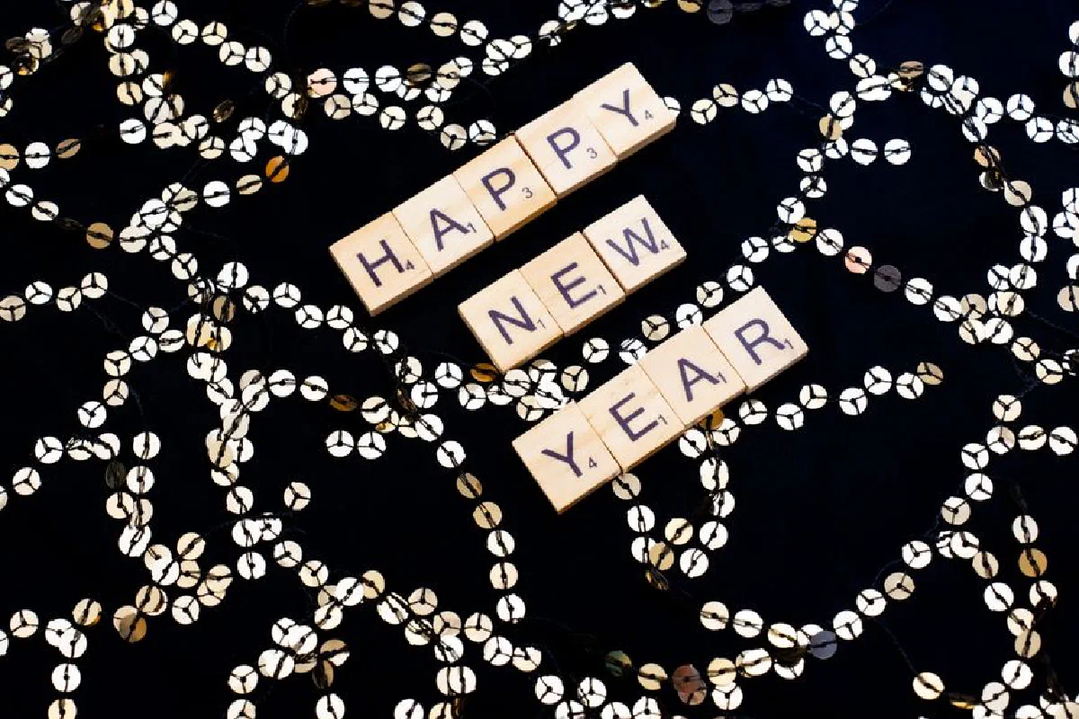 Scrabble tiles spell out 'Happy New Year' with festive decorations in Paris, France.