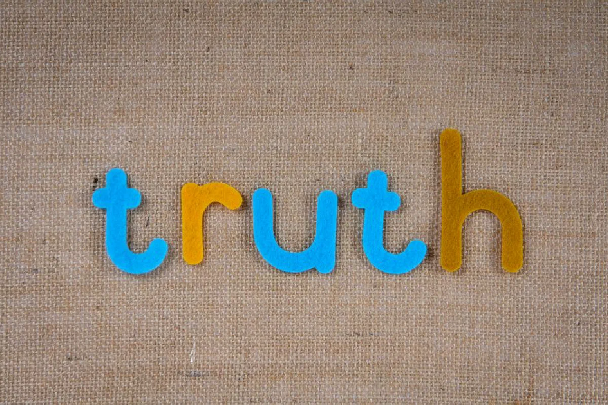The word 'truth' in colorful felt letters on a burlap background.