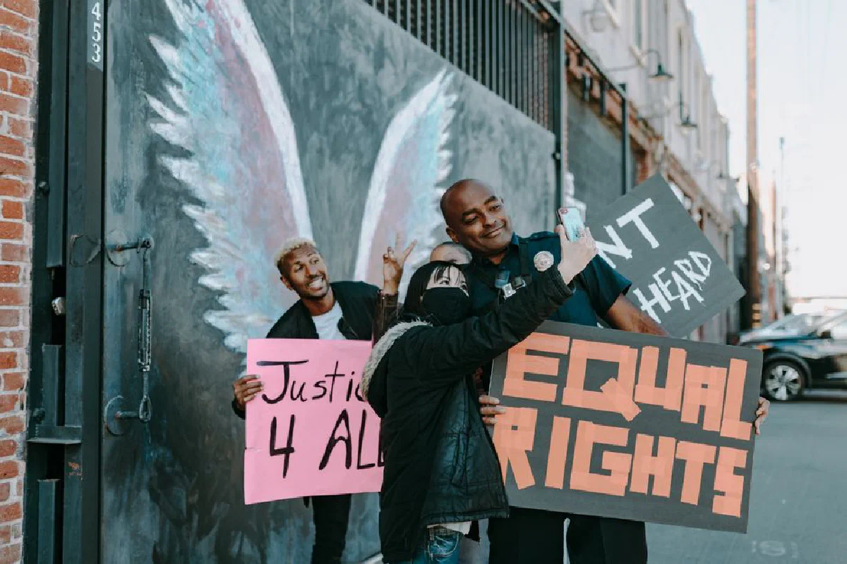 Participants holding signs for justice and equal rights at an outdoor protest.