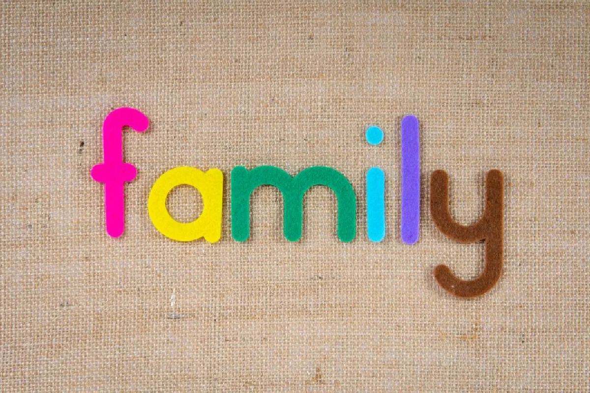 Vibrant letters spelling 'family' on a textured burlap background, emphasizing togetherness.
