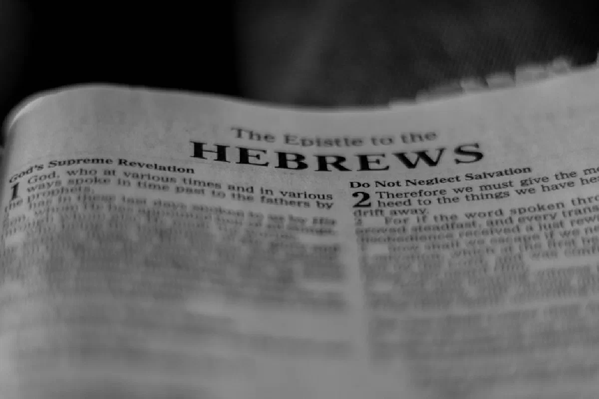 Black and white close-up of Hebrews chapter in a Bible, focused on text.