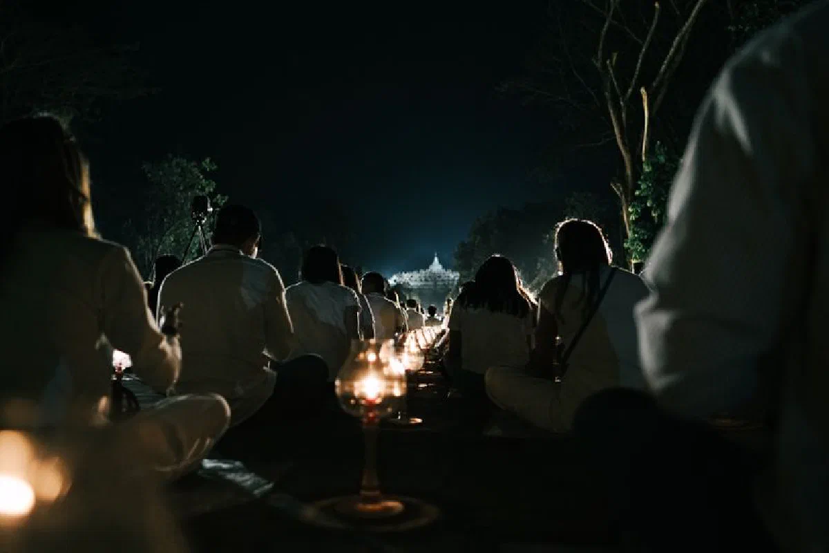 Silhouettes meditating in Borobudur's night gathering, Central Java.