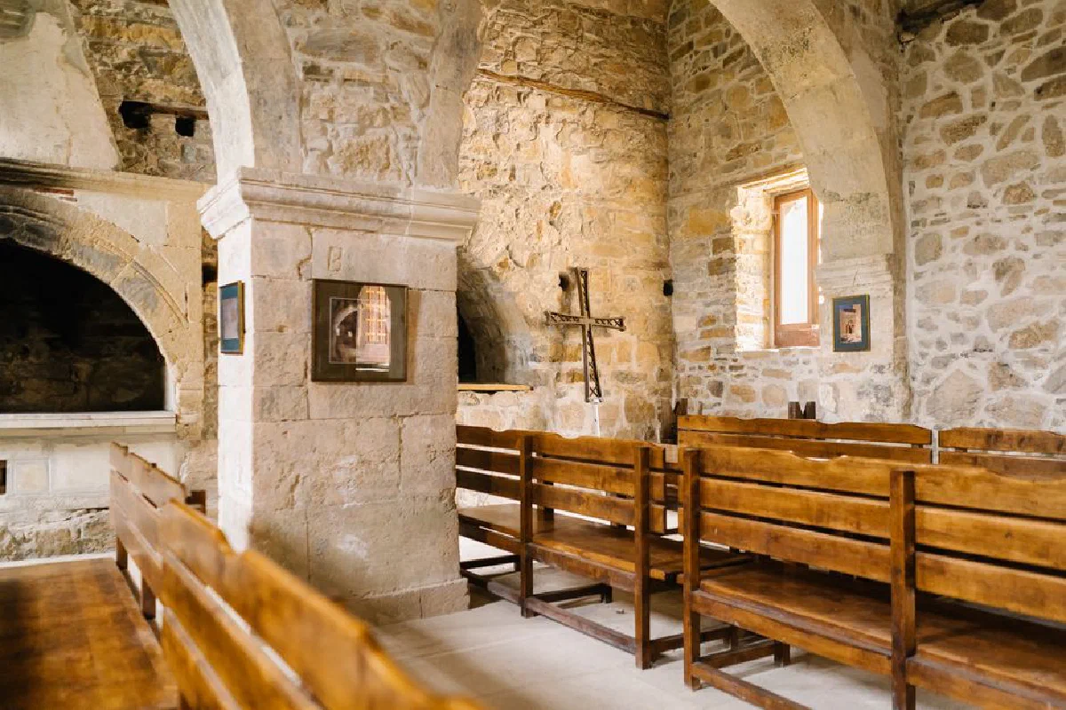 Captivating view of a historic stone church interior with wooden pews and arched architecture.