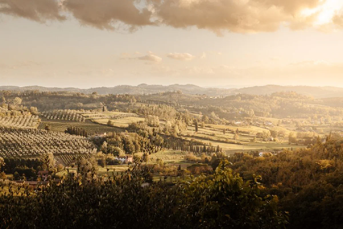 A breathtaking view of the Tuscan countryside at sunset, showcasing rolling hills and lush greenery.