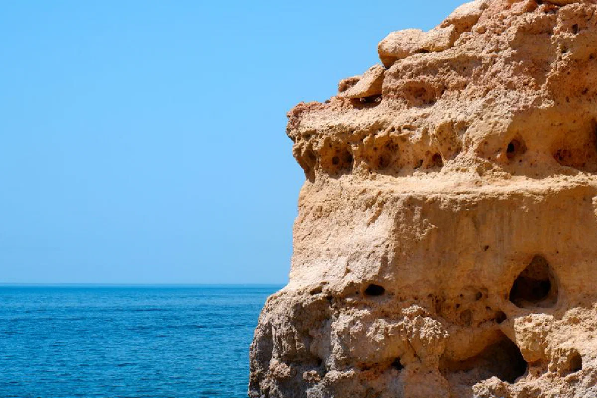 A breathtaking view of limestone cliffs against the azure Atlantic Ocean in Algarve, Portugal.