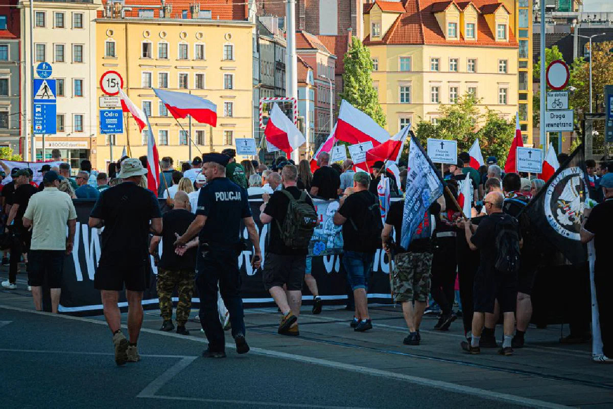 A march in Wrocław, Poland with people holding flags and signs, commemorating the Wolyn events.