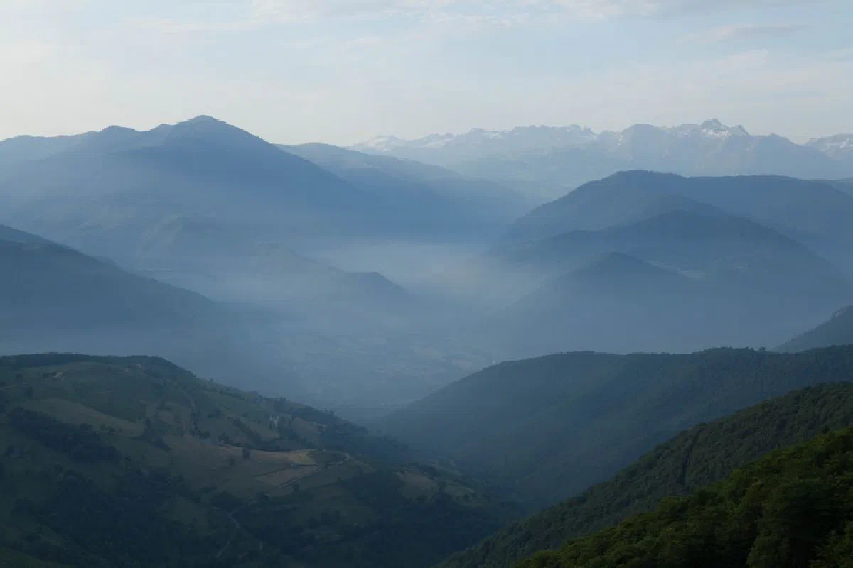 Peaceful view of misty mountain ranges in Luz-Saint-Sauveur, France at dawn.