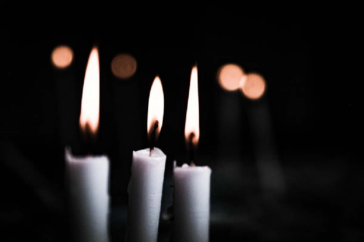 A focused shot of lit candles casting warm light in a dark ambiance.