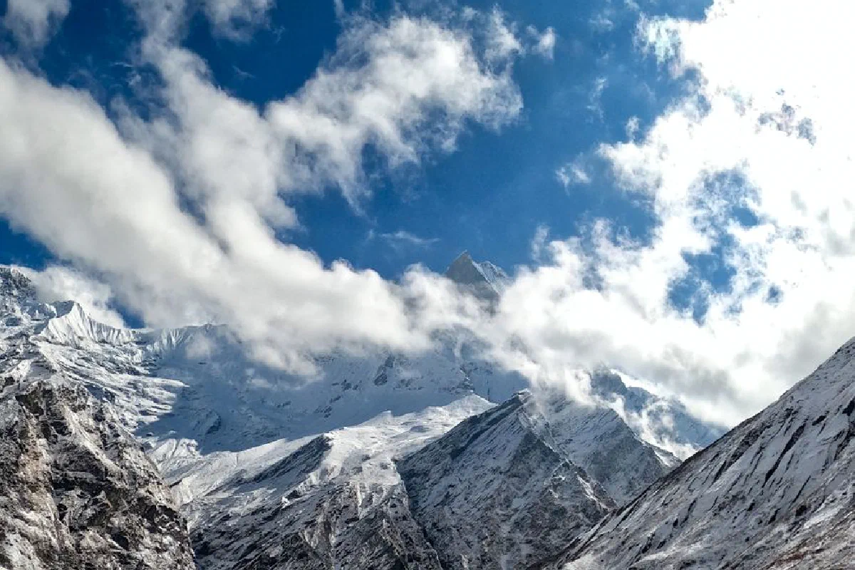 Stunning view of snow-covered Himalayan peaks beneath a vibrant blue sky, offering a captivating natural scenery.