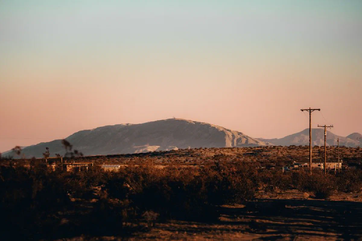 A serene desert landscape featuring mountains and a sunset, creating a warm and tranquil atmosphere.
