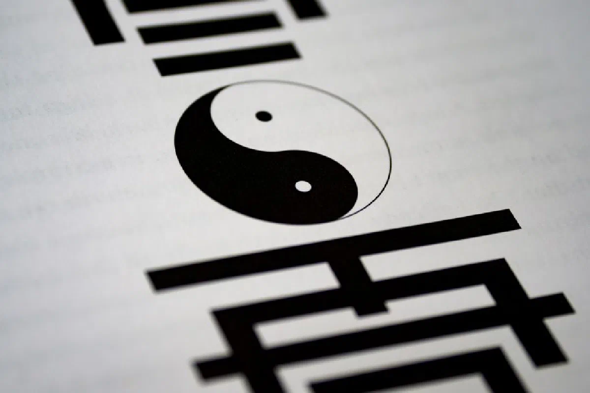 Artistic close-up of yin-yang symbol with Chinese calligraphy on paper.
