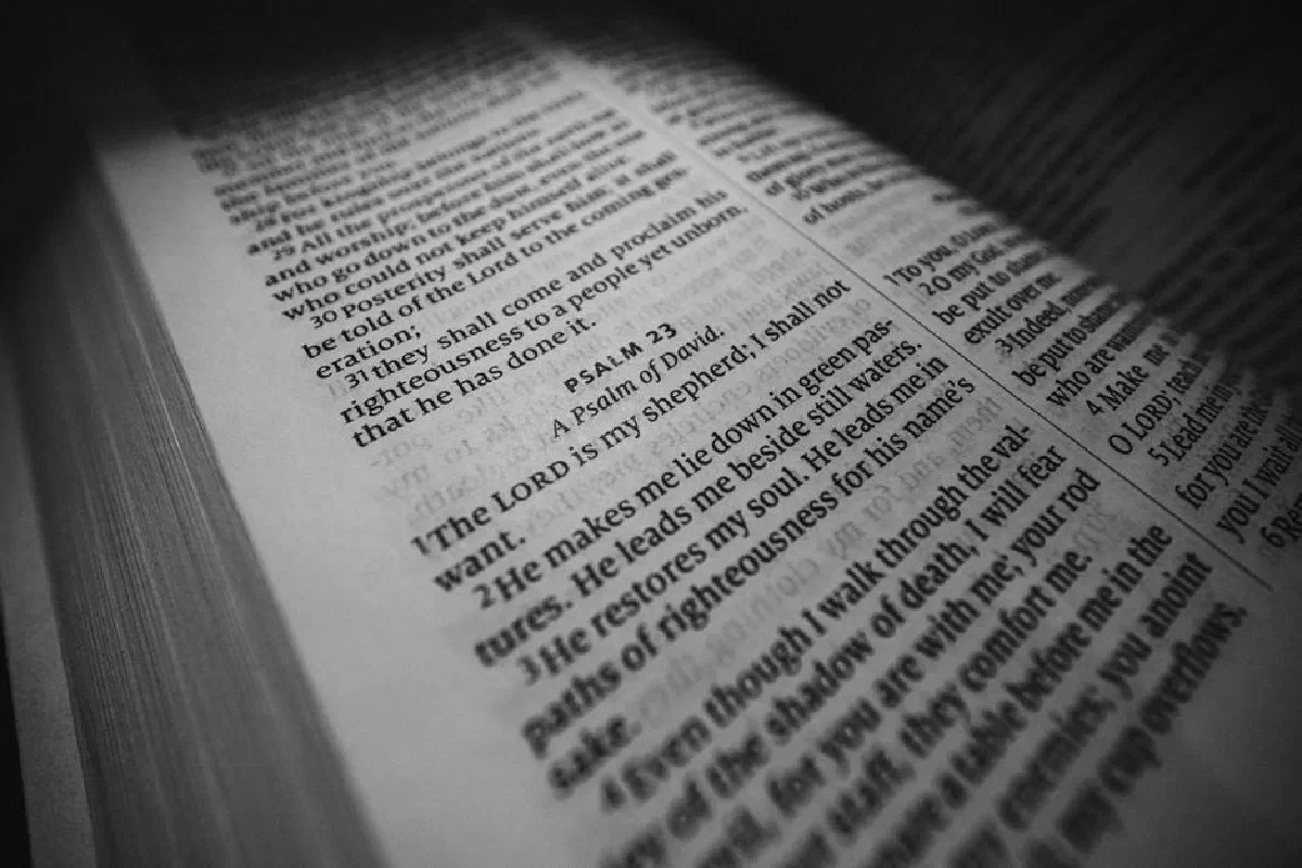 Black and white close-up of Psalm 23 in an open Bible, emphasizing spiritual serenity.