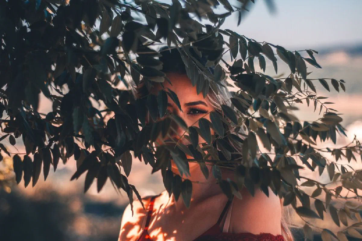 Portrait of a woman partially hidden by leaves in Arruda dos Vinhos, Portugal.