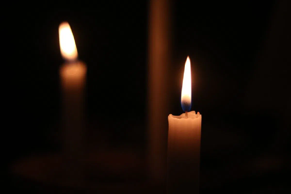 Soft candle flames illuminate the darkness, creating a peaceful atmosphere.