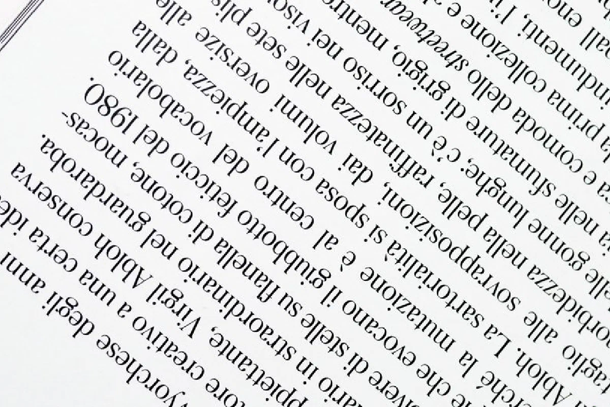 Close-up view of upside down printed text on a white page, highlighting the font and arrangement.