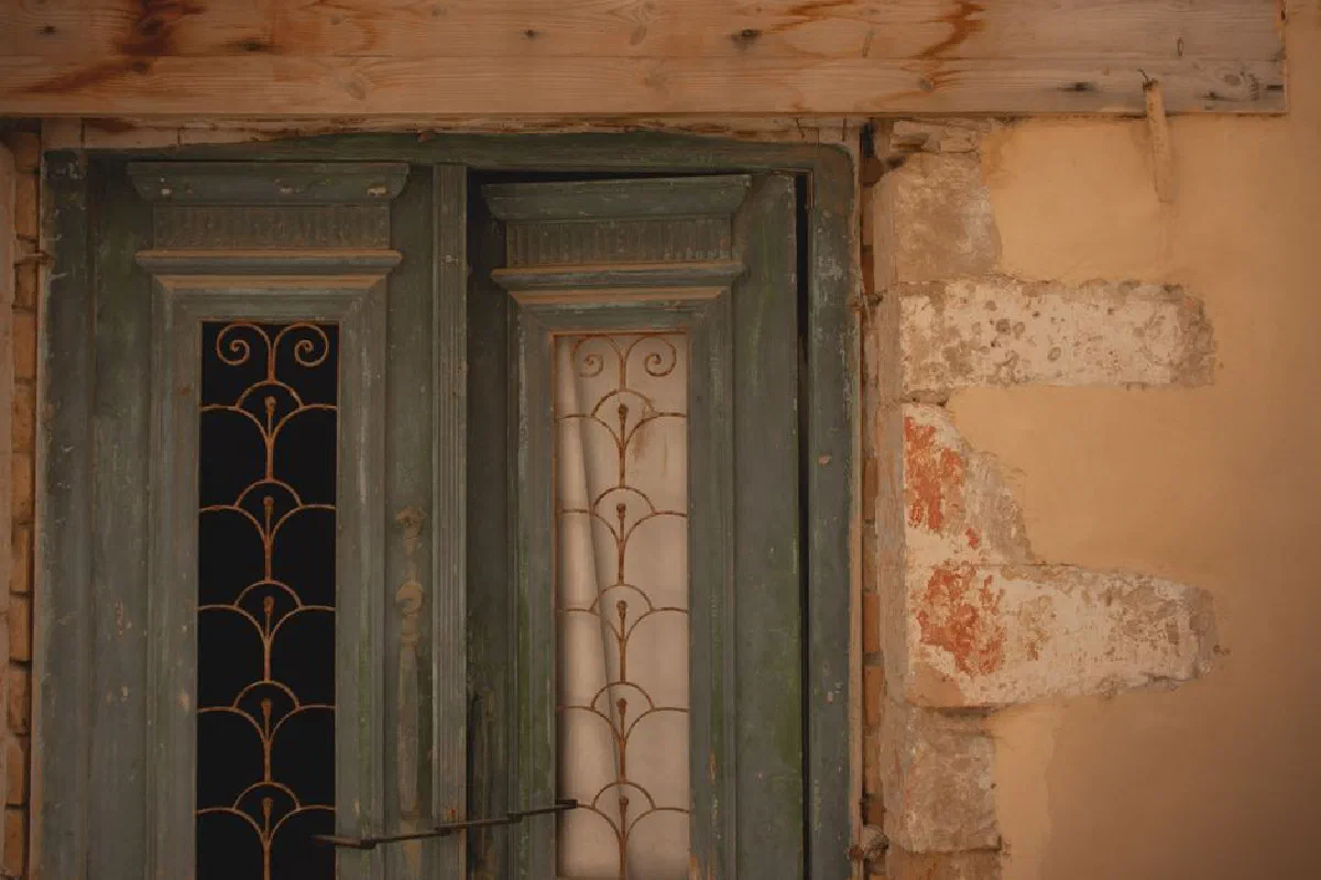 Weathered double doors with ornate design in Athens, Greece. A rustic and vintage look.