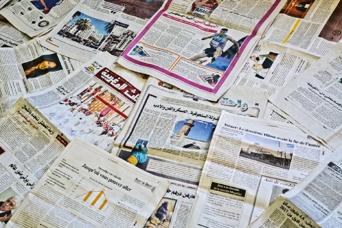 Close-up view of various newspapers laid out, showcasing diverse headlines and articles.