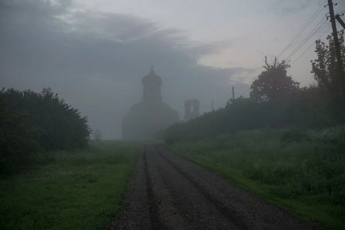 Foggy morning view of an ancient church in Russian countryside.