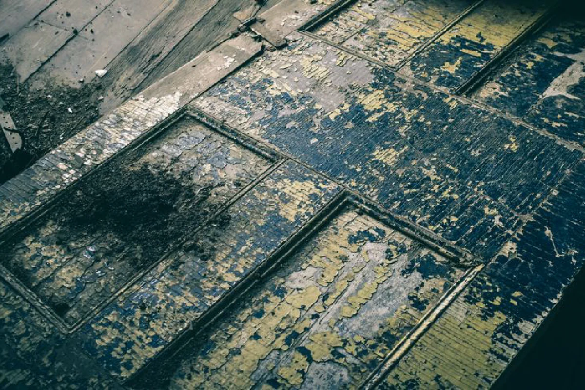 A detailed shot of a rustic and decayed wooden door with peeling paint, showcasing textures and vintage charm.