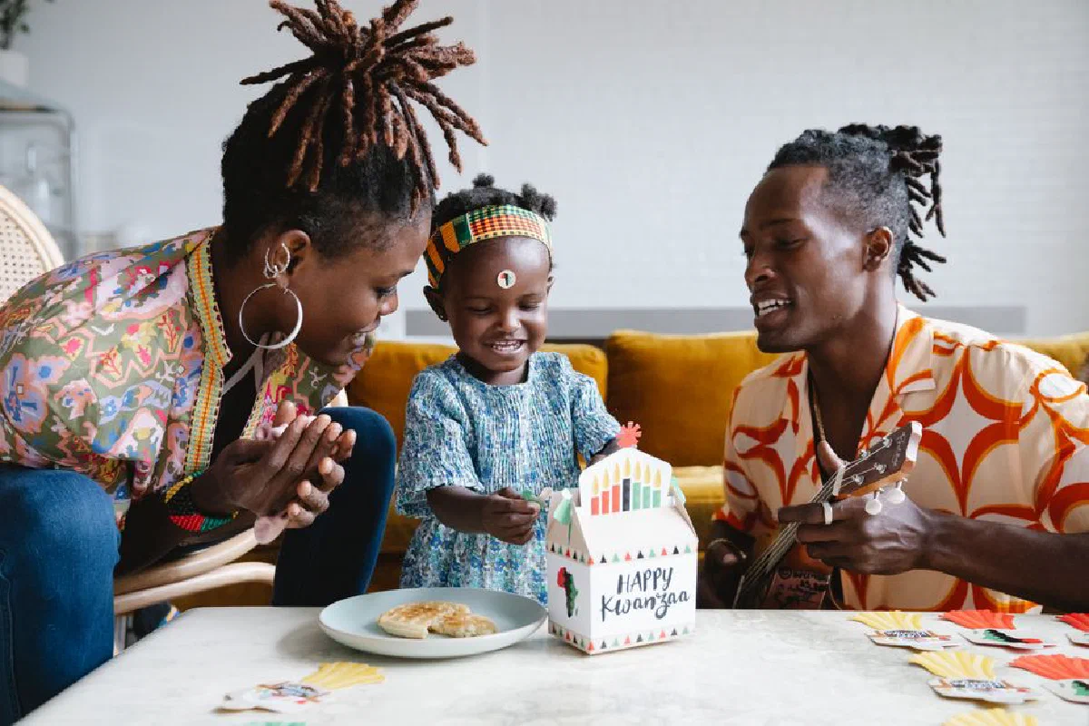 Joyful family celebrating Kwanzaa at home with gifts and music.
