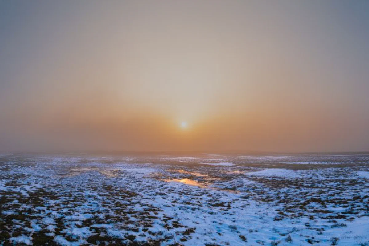 Captivating winter landscape with snowy fields at sunset, showcasing serene beauty.