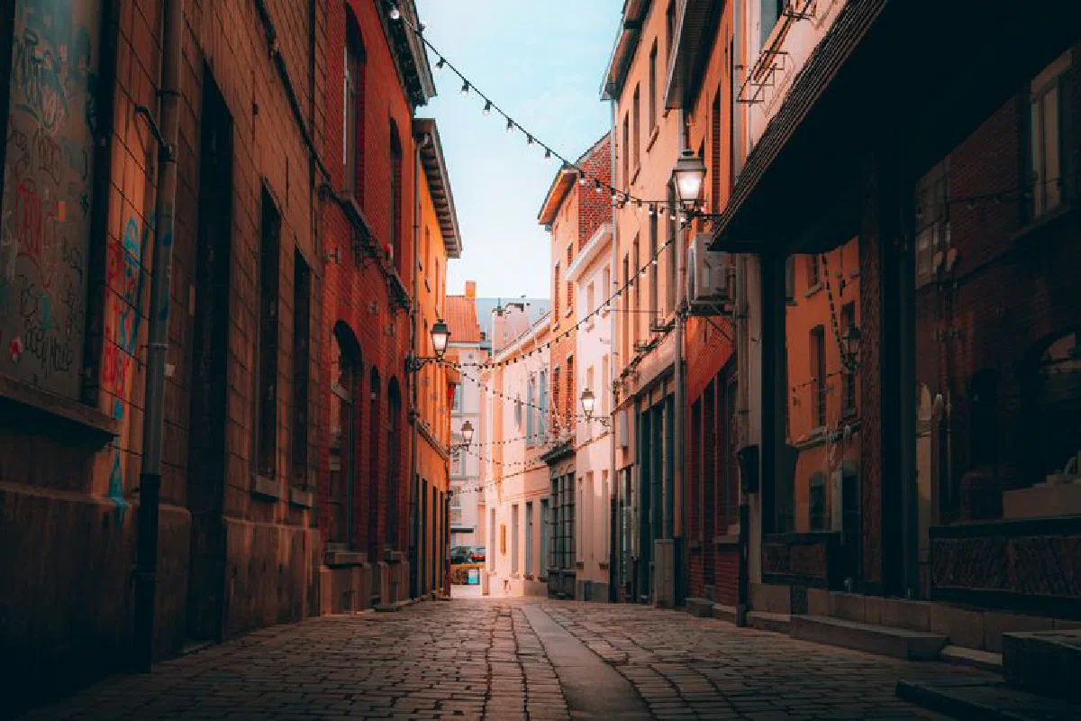 Quaint alleyway with cobblestone pavement and string lights, perfect for evening strolls.