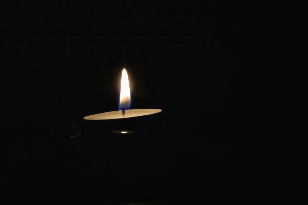 Close-up of a single candle illuminating darkness, creating a peaceful ambiance.
