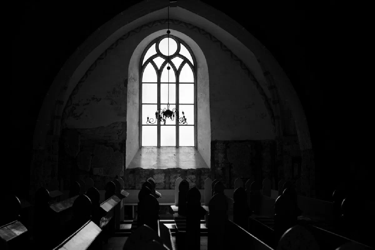 Intriguing black and white photo of a church interior featuring a gothic arched window. Captured in Cēsu novads, Latvia.