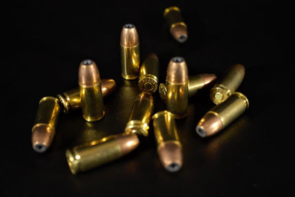A collection of golden bullets arranged on a dark surface, captured in close-up.