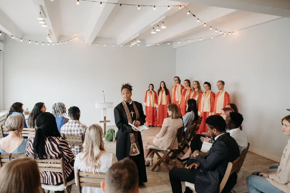 A religious ceremony featuring a diverse choir and an attentive congregation indoors.