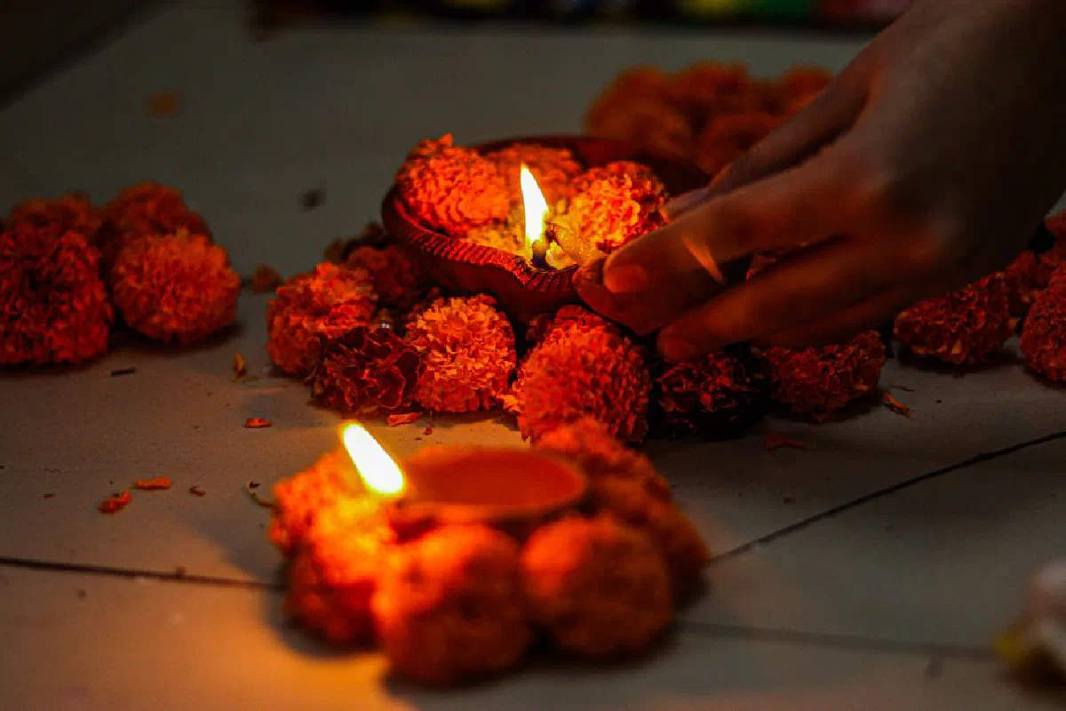 Warm close-up of marigold flowers with candles during a traditional ceremony lighting.