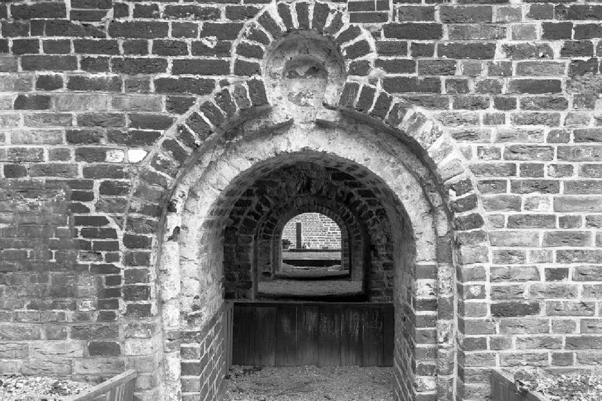 A black and white photo showcasing a series of historic brick archways in Jemgum, Niedersachsen, Germany.