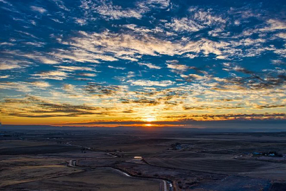 A stunning aerial view capturing the Idaho countryside with a vibrant sunset and vast open fields.