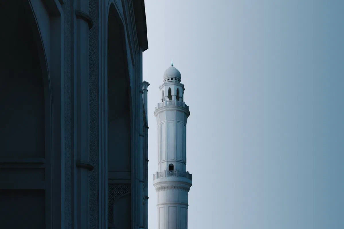 Captivating view of a mosque's minaret in Indonesia during the serene blue hour, showcasing Islamic architecture.