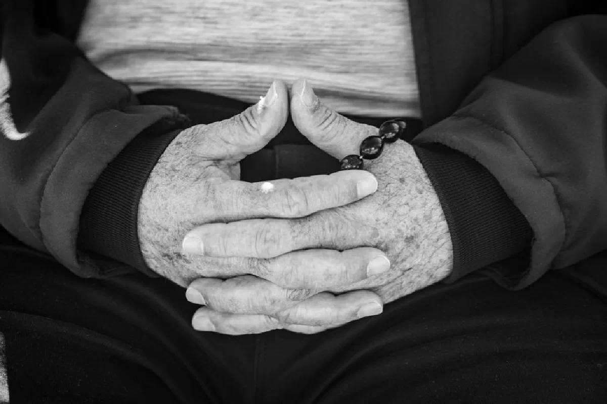 Close-up of senior hands with prayer beads, symbolizing reflection and tranquility.