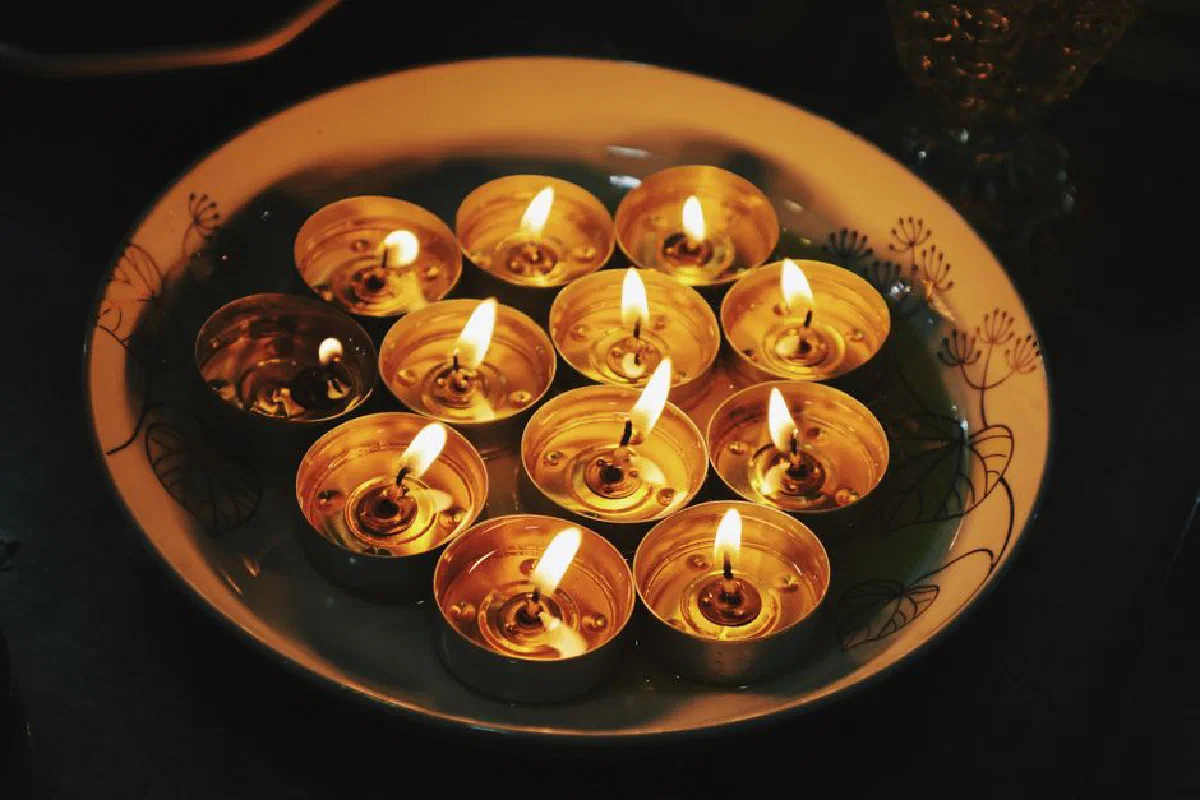 A close-up of lit candles in a decorative plate creating a warm ambiance.