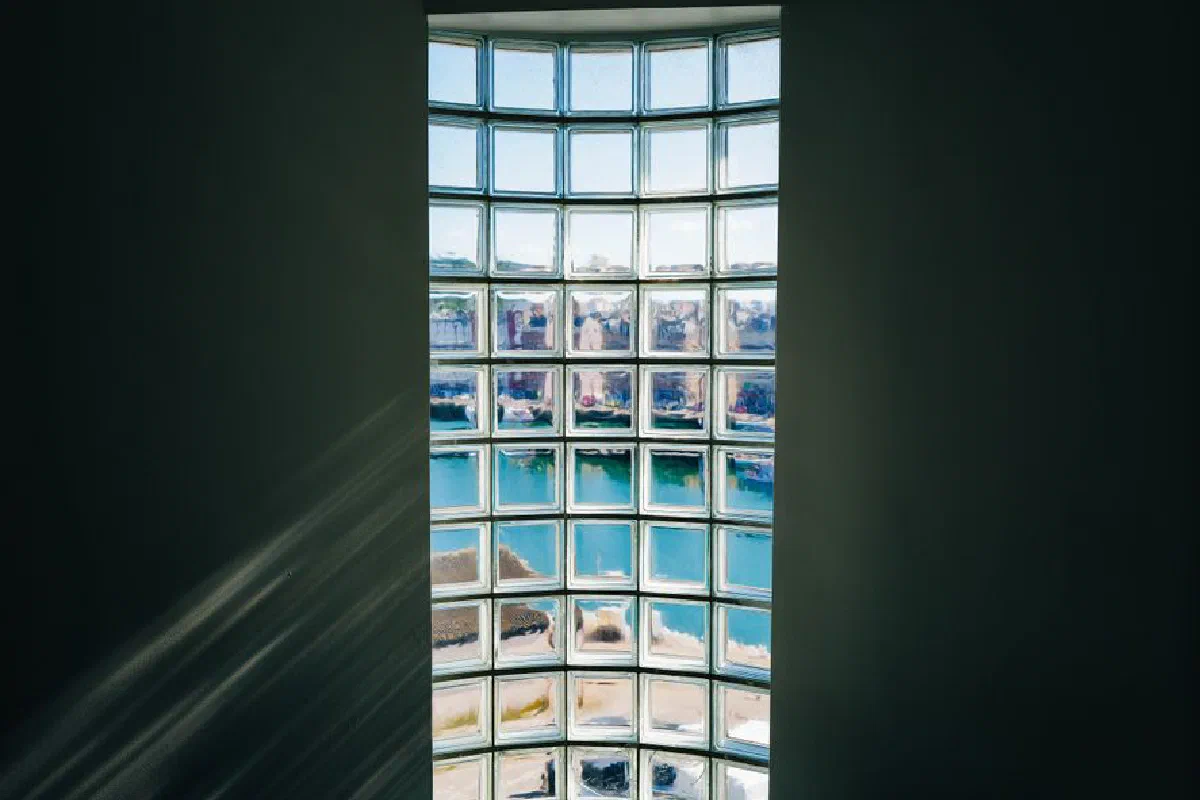 A beautiful view of the cityscape through a glass block window, capturing bright reflections.