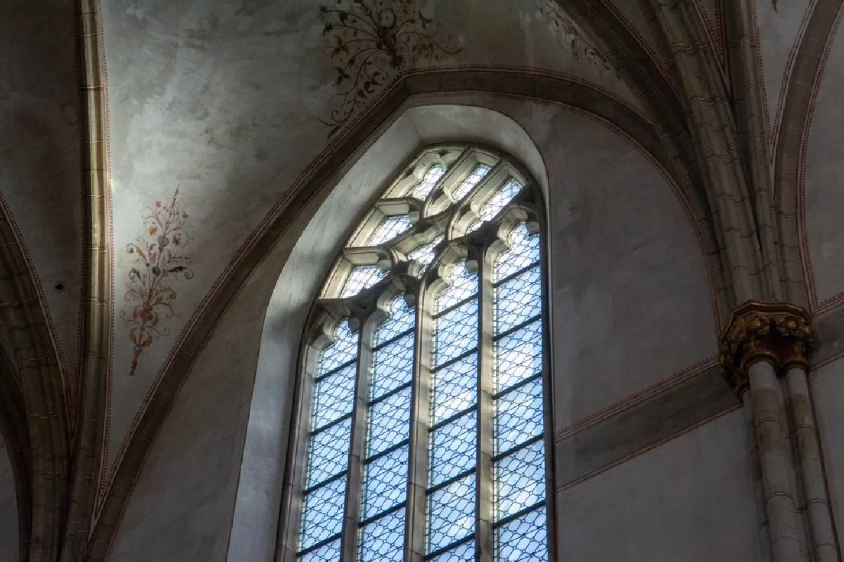 Explore the intricate beauty of a Gothic cathedral with illuminated stained glass windows and ornate rib vaults.