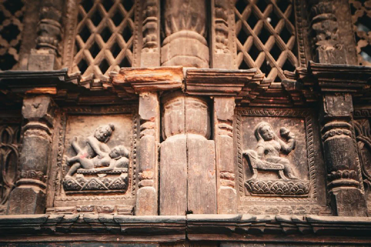 Detailed ancient stone carvings featuring human figures on a historic building facade.