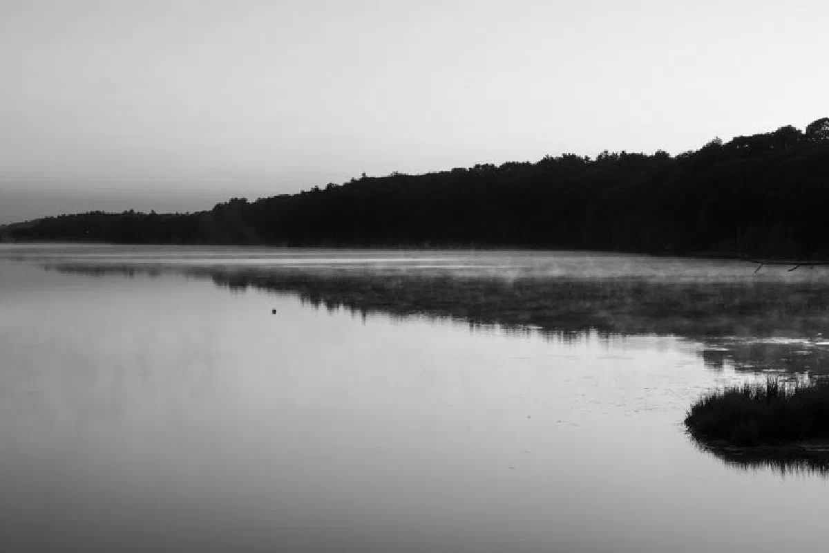 Black and white photo of a misty river at sunrise in Brunswick, Maine, USA, creating a tranquil scene.